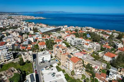 an aerial view of a city and the water at In And Out in Chania Town