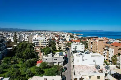 an aerial view of a city with buildings and the ocean at In And Out in Chania Town