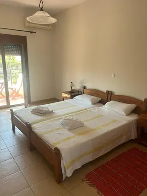 a bedroom with a large bed with white sheets at Kandania Apartments in Kántanos