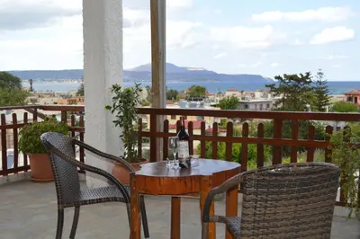 a table and chairs with a bottle of wine on a balcony at Sofia Kalyves in Kalyves