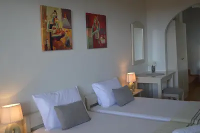 a bedroom with a white bed and a painting on the wall at Sofia Kalyves in Kalyves