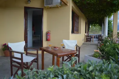 a wooden table and chairs with wine glasses on a patio at Sofia Kalyves in Kalyves