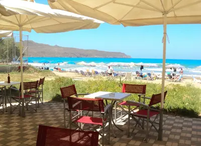a table and chairs with a view of the beach at Thodorou Villa in Agia Marina Nea Kydonias