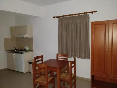 a kitchen with a table and chairs in a room at Sifis Studios in Palaiochóra