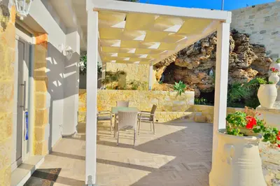 a patio with a table and chairs under a pergola at Koukis House With Sea View in Falasarna