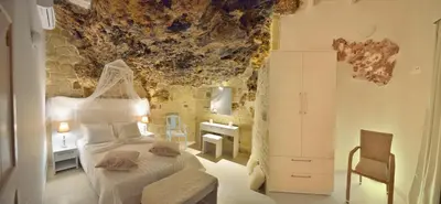 a bedroom with a bed and a rock ceiling at Koukis House With Sea View in Falasarna