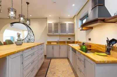 a large kitchen with white cabinets and a large mirror at Elements Villa in Galangádhos
