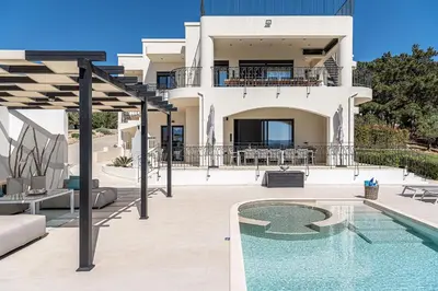 a villa with a swimming pool in front of a house at Luxury Apartment with private pool in Tavronitis