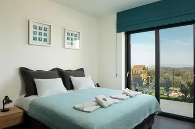 a bedroom with a large bed with towels on it at Luxury Apartment with private pool in Tavronitis