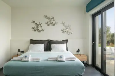 a bedroom with a bed with two towels on it at Luxury Apartment with private pool in Tavronitis