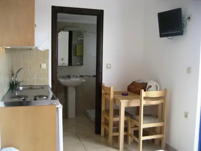 a small kitchen with a sink and a table with a sink at Yiorgos Studios in Palaiochóra