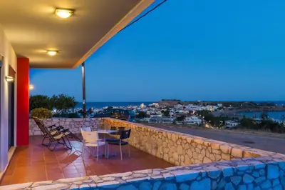 a house with a balcony with a view of the city at Caravella Luxury Apartments in Palaiochóra