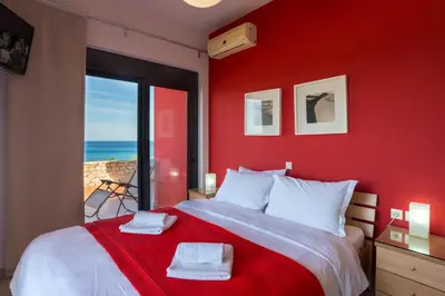 a red bedroom with a bed with a red wall at Caravella Luxury Apartments in Palaiochóra