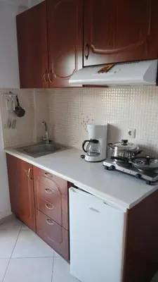 a kitchen with wooden cabinets and a white counter top at Zorbas Studios in Agia Roumeli