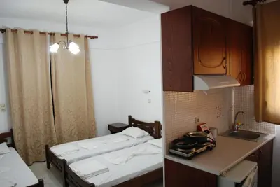 a small room with two beds and a kitchen at Zorbas Studios in Agia Roumeli
