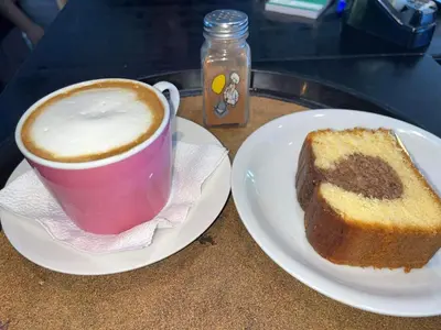 a cup of coffee and a piece of bread on a table at Haris Studios in Palaiochóra