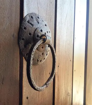 a metal door knocker on a wooden door at Bendeni Cottage in Megála Khoráfia