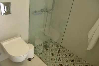 a bathroom with a toilet and a glass shower at Sixteen All Seasons House in Chania Town