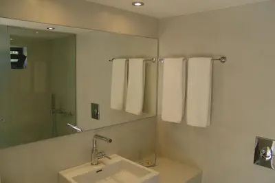 a bathroom with a sink and a mirror and towels at Sixteen All Seasons House in Chania Town