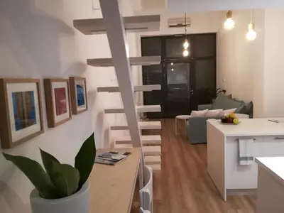 a kitchen and a living room with a spiral staircase at Sixteen All Seasons House in Chania Town