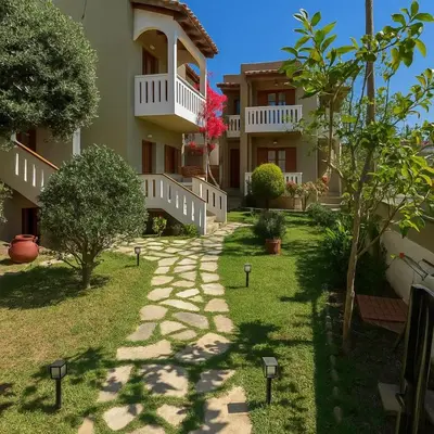 a walkway in front of a building with trees at Nicolas Beach in Palaiochóra