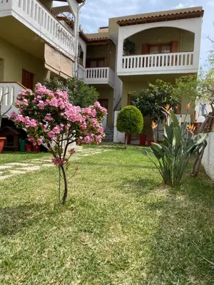 a house with pink flowers in the yard at Nicolas Beach in Palaiochóra
