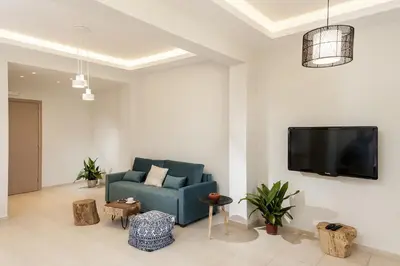 a living room with a blue couch and a flat screen tv at Villa Anemi in Stérnai