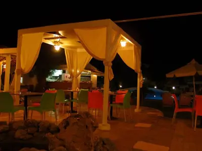 a table and chairs under a canopy at night at Hippokratis Apartments in Gerani Chanion