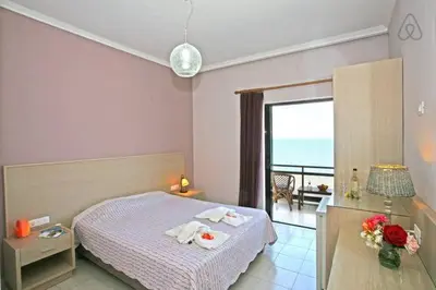 a bedroom with a bed and a view of the ocean at Akrogiali in Kissamos