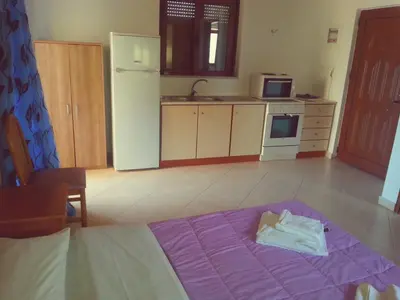 a kitchen with a purple bed in a room at Akrogiali in Kissamos