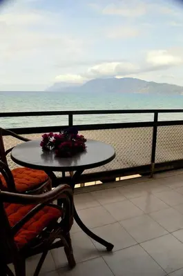 a table and a chair with flowers on a balcony at Akrogiali in Kissamos