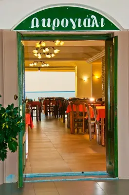 a restaurant with tables and chairs and a sign at Akrogiali in Kissamos