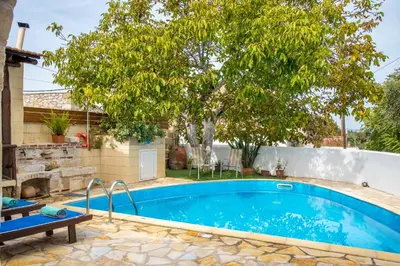 a swimming pool in a yard with a tree at GrapeVine Villa in Gavalochori