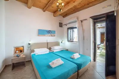 a bedroom with a blue bed with towels on it at GrapeVine Villa in Gavalochori