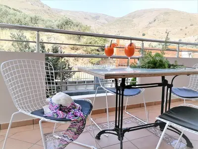 a table and chairs on a balcony with a view at Villa Aeolus with private overflow, endless, heated pool in Prinés
