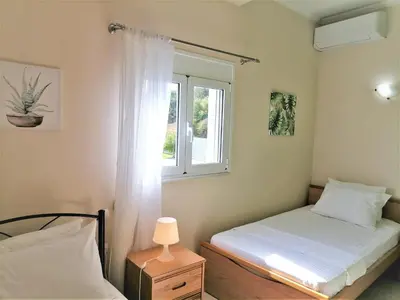 a bedroom with two beds and a window at Villa Aeolus with private overflow, endless, heated pool in Prinés