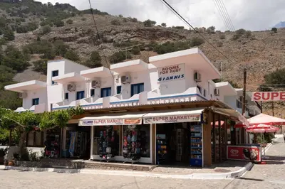 a store in front of a white building at Giannis Rooms in Agia Roumeli