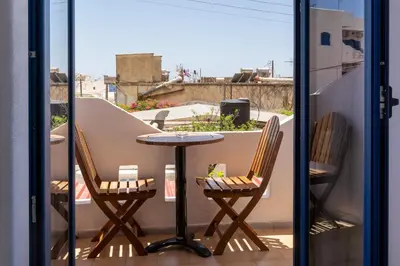 a table and two chairs on a balcony at Giannis Rooms in Agia Roumeli