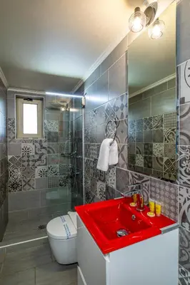a bathroom with a red sink and a toilet at Areti Suites in Kathiana