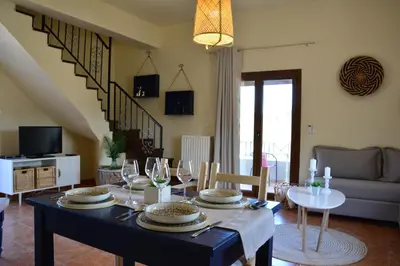 a dining room with a table with wine glasses at Elianthos Villas in Vamos