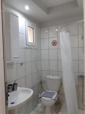 a white bathroom with a toilet and a sink at Dennis Stylish Apartment in Kato Daratso