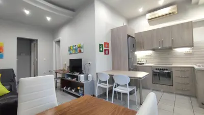 a kitchen with a table and chairs in a room at Dennis Stylish Apartment in Kato Daratso