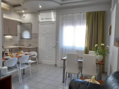 a kitchen and living room with a table and chairs at Dennis Stylish Apartment in Kato Daratso