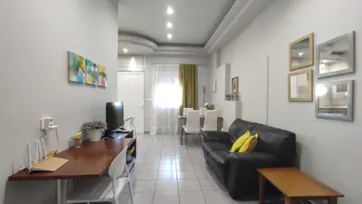 a living room with a black leather couch and a table at Dennis Stylish Apartment in Kato Daratso
