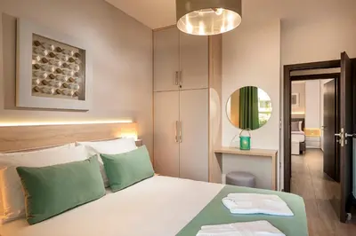 a bedroom with a bed with green and white pillows at Amaen Luxury House in Perivólia