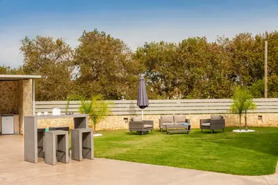 a patio with a table and chairs and an umbrella at Amaen Luxury House in Perivólia