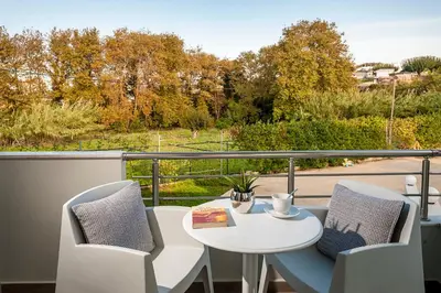 a white table and chairs on a balcony with a view at Amaen Luxury House in Perivólia