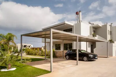a car parked under a garage in front of a house at Amaen Luxury House in Perivólia