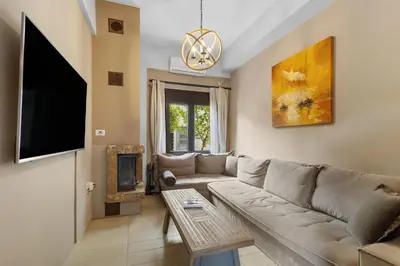 a living room with a couch and a tv at Casa Veranda - 3 Bedroom House with BBQ & Backyard in Chania Town