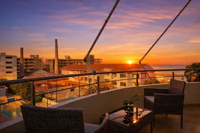 a balcony with a view of the ocean at sunset at Pilot Lux Apartment in Chania Town